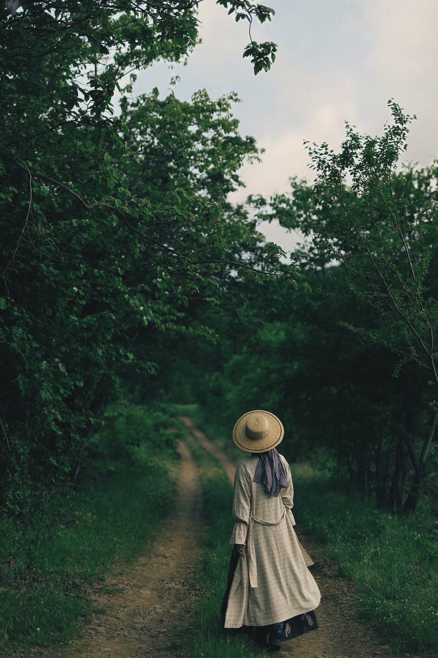 The back of a woman looking down an empty path.
