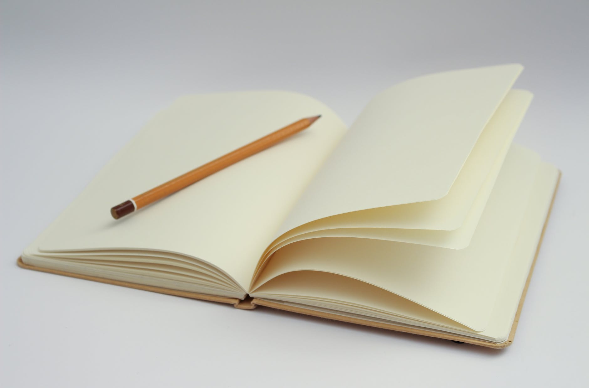Empty pages of a book with a pencil.